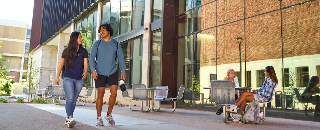 Two UArizona students walking outside on campus